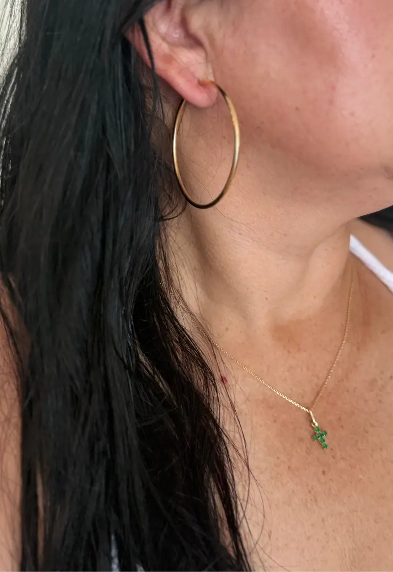 Modelo luciendo aretes en oro y collar de oro con esmeraldas