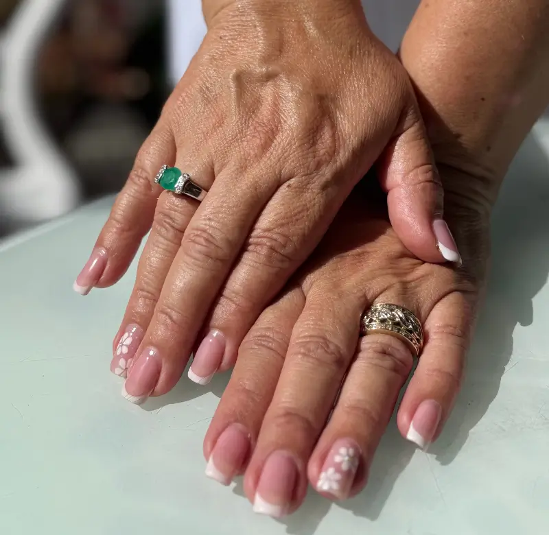 Modelo luciendo anillos con esmeraldas a la luz del sol